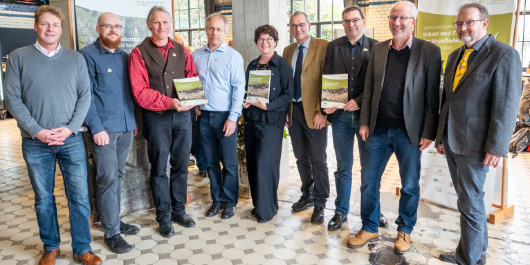 Präsentation des Praxisleitfadens zum Schutz der Mopsfledermaus im Rahmen der Tagung (v. l. n. r: Dr. Holger Buschmann (NABU Niedersachsen), Robert Pfeifle (NABU Baden-Württemberg), Martin Biedermann (Stiftung FLEDERMAUS), Dr. Ivo Niermann (NABU Niedersachsen), Sabine Riewenherm (Bundesamt für Naturschutz), Burkhard Schneider (Bundesforst), Adrian Johst (Naturstiftung David), Dr. Hans-Jürgen Schäfer (Thüringer Umweltministerium), Prof. Dr. Gerald Kerth (Universität Greifswald)), Foto: Thomas Müller 